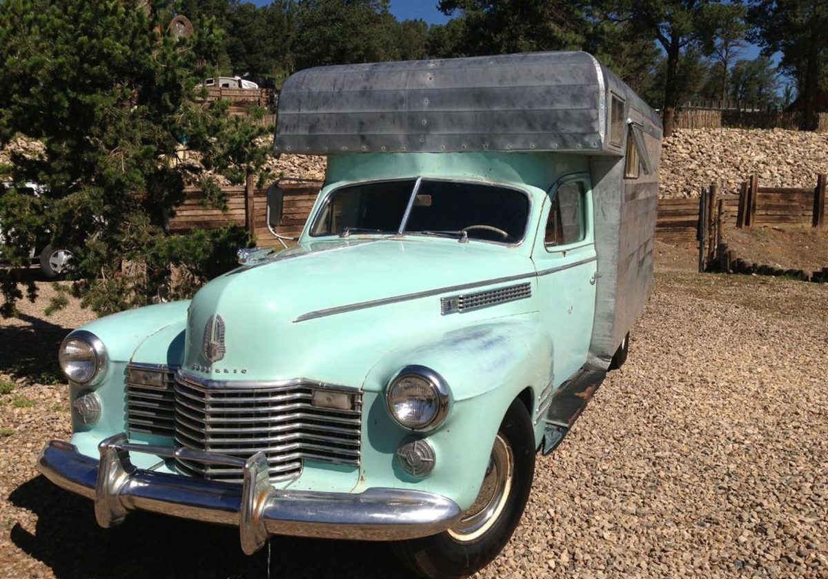 A vintage mint green pickup parked among the ponderosa at the park